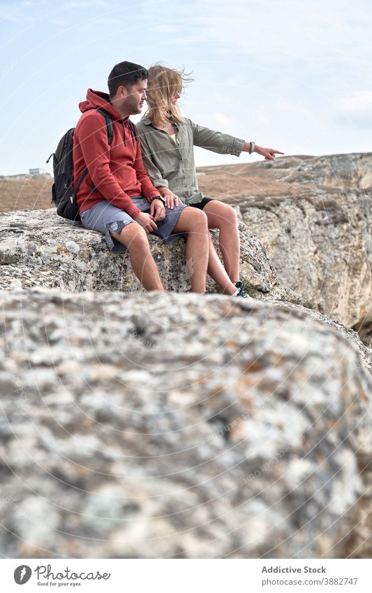 Reisendes Paar, das sich während des Trekkings auf einem Hügel ausruht reisen Wanderer felsig Berge u. Gebirge sich[Akk] entspannen Entdecker Zusammensein Natur