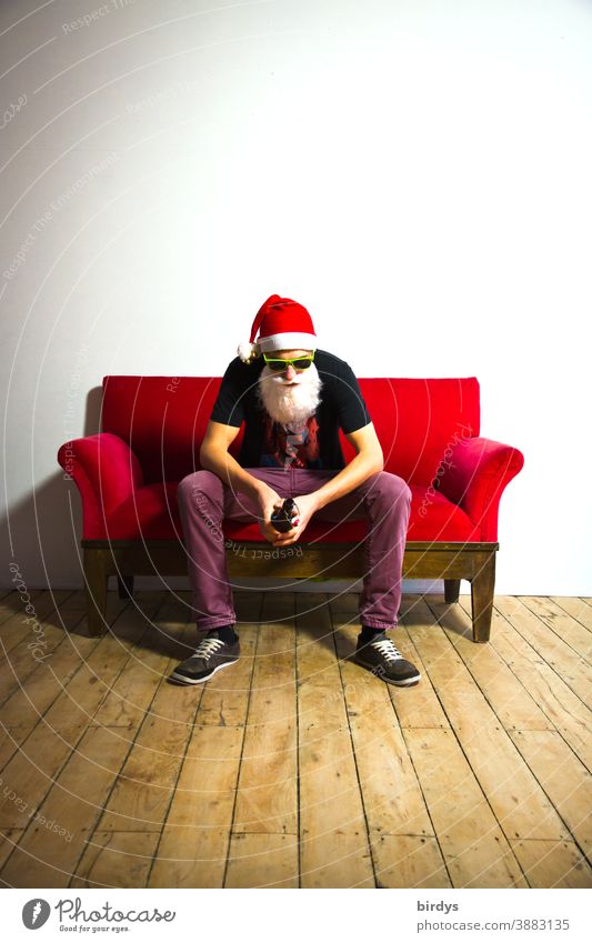 frustrierter Weihnachtsmann mit Bierflasche auf einem roten Sofa Nikolaus Nikolausmütze Weihnachtsmannmütze Weihnachten Weihnachten & Advent Frust