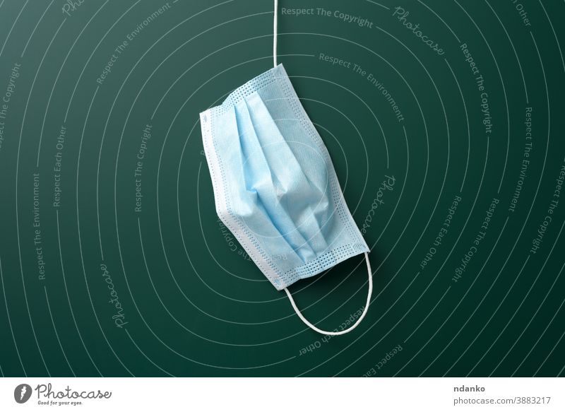 medizinische Einwegmaske, die auf einer leeren grünen Kreidetafel hängt Mundschutz hängen Schule Medizin Pandemie Lungenentzündung Prävention behüten Schutz