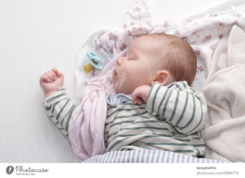 Baby schläft auf einem Bett mit Decken Kleinkind Schnuller Tuch schlafen Mittagsschlaf friedlich ruhig träumen Gesicht