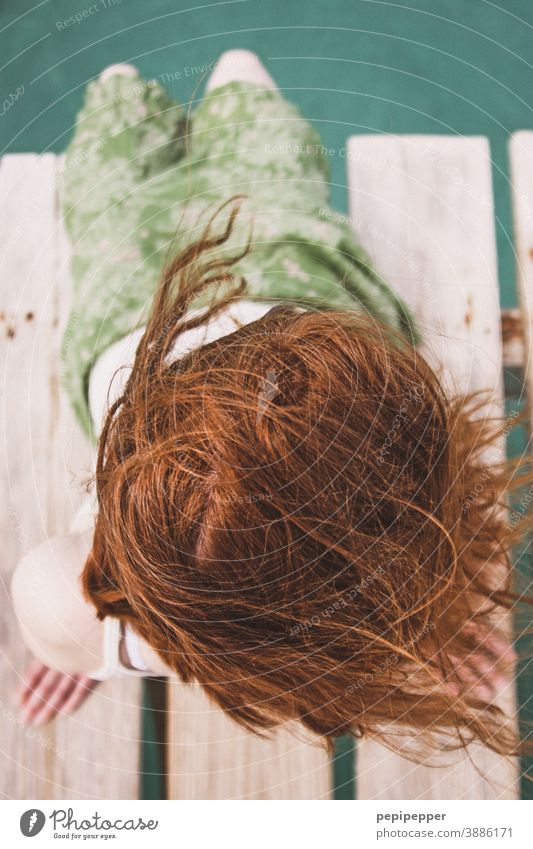 junge, rothaarige Frau sitzt entspannt auf einem Wassersteg am Meer Fälschung Urlaub Natur Reise Erholung Kleidung Felsen Haare verrotten Strang Sommer sehen