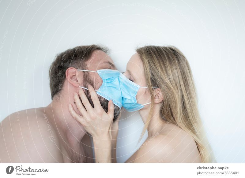 Mann und Frau küssen sich mit Maske mund-nasen-schutz Corona covid-19 COVID Coronavirus Mundschutz Pandemie Corona-Virus Schutz Infektionsgefahr Kuss Schützen