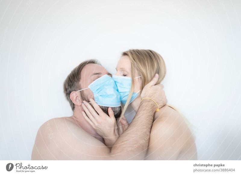 Mann und Frau küssen sich mit Maske mund-nasen-schutz Corona covid-19 COVID Coronavirus Mundschutz Pandemie Corona-Virus Schutz Infektionsgefahr Kuss Schützen