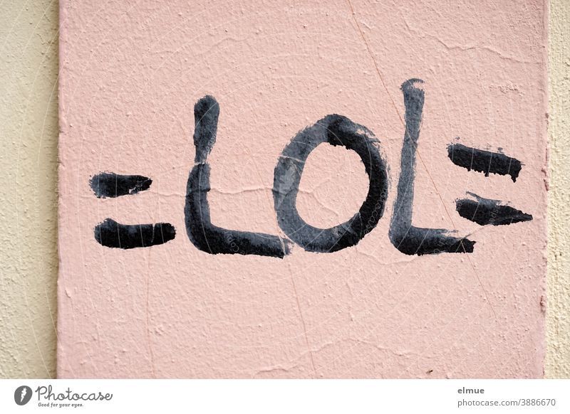 "=LOL=" steht in schwarzen Druckbuchstaben auf einer rosafarbenen verputzten Wand / Netzjargon / Jugendsprache lol lachen Verständigung lautes Lachen