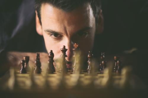Mann spielt Schach Erfolgsaussicht Strategie konzept planung Sicherheit spielen Herausforderung Schachbrett Verstand denken Stratege ehrgeizig Duell