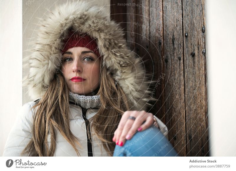 Stilvolle Frau in Oberbekleidung in der Stadt warm Jacke Großstadt warme Kleidung Winter kalt Saison Straße gestrickt Hut hölzern sich[Akk] entspannen Tür