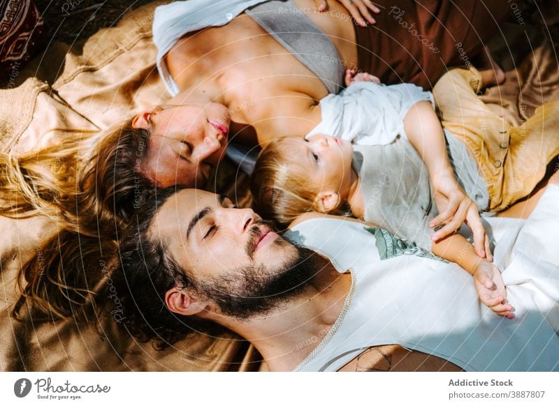 Sanfte Familie entspannt gemeinsam in der Natur Decke Hippie Pflege Lügen sich[Akk] entspannen Zusammensein Angebot Sonnenlicht rassenübergreifend multiethnisch