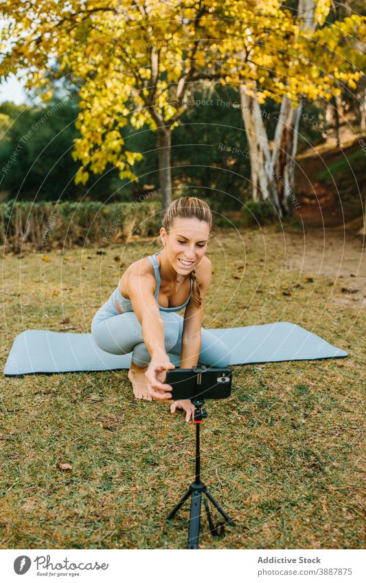 Yogalehrer bereitet sich auf Online-Praxis im Park vor Frau online Smartphone Ausbilderin vorbereiten üben Telefon Video Tutorial Filmmaterial digital Mobile