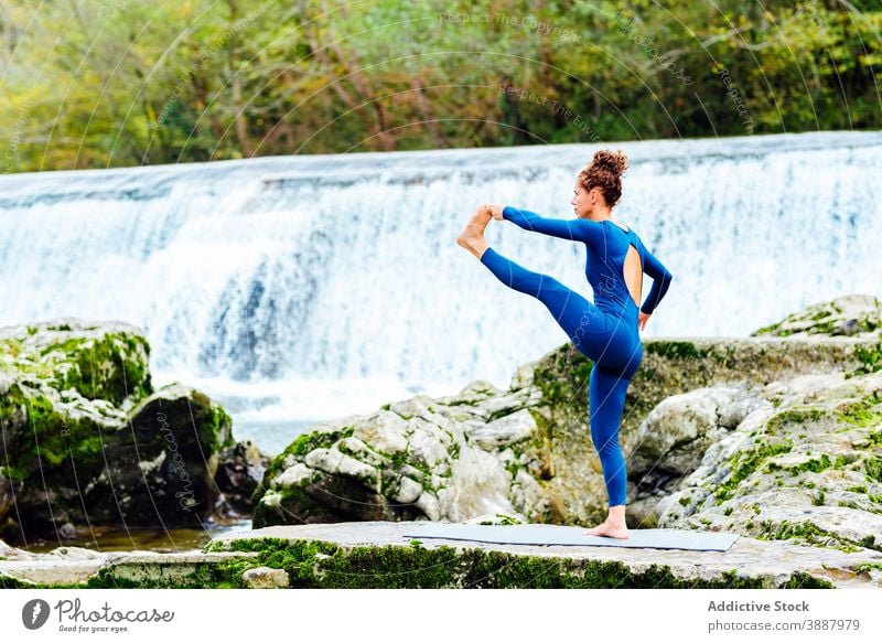 Frau macht Yoga in Stehende Hand zu Fuß Pose in der Natur Hand-zu-Fuß-Pose beweglich Asana üben Wasserfall Gleichgewicht hasta padangusthasana Unterlage ruhig