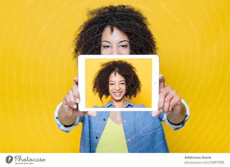 Fröhliche schwarze Frau nimmt Selfie mit Tablette Bildschirm fotografieren heiter Glück digital Apparatur benutzend Gerät jung Afroamerikaner ethnisch Hipster