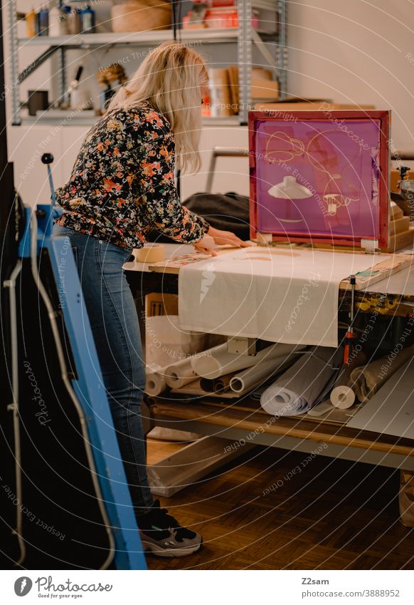 Junge Frau arbeitet in der Siebdruckwerkstatt illustration produktion siebdruck workshop siebdruckwerkstatt kreative kreation handarbeit handcraft brille hübsch