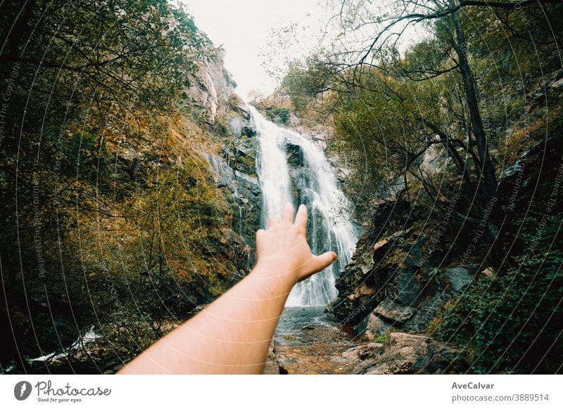 Horizontale Aufnahme einer unscharfen Hand, die einen massiven Wasserfall erreicht Natur Baum Western Gelassenheit Landschaft natürlich friedlich Laubwerk