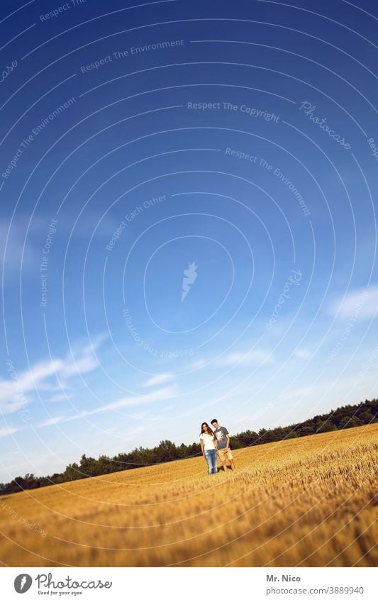 Junges Paar steht auf einem Stoppelfeld Feld Natur Ernte Landwirtschaft Landschaft Sommer Himmel Sympathie Schönes Wetter verliebt Zusammensein Partnerschaft