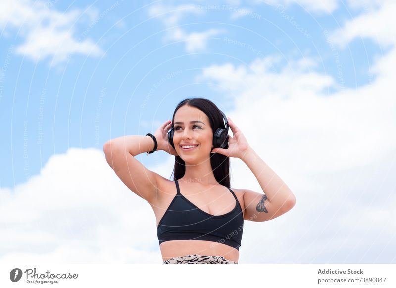Glückliche Frau mit Kopfhörer auf der Straße passen benutzend heiter zuhören aktiv positiv jung Musik Drahtlos Mobile Telefon Training Apparatur Gerät Lifestyle