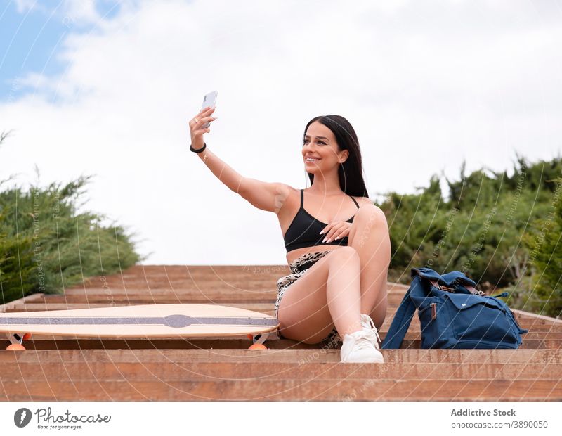 Glückliche Frau mit Longboard unter Selfie auf der Straße Smartphone passen Lächeln positiv sportlich Telefon Mobile jung Gerät Lifestyle heiter Optimist