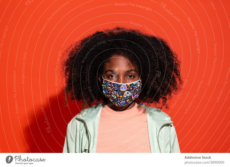 Schwarze Frau mit Schutzmaske im Studio Mundschutz behüten verhindern Textil Gewebe Menschliches Gesicht emotionslos Frisur Pandemie Zeitgenosse hell Stil