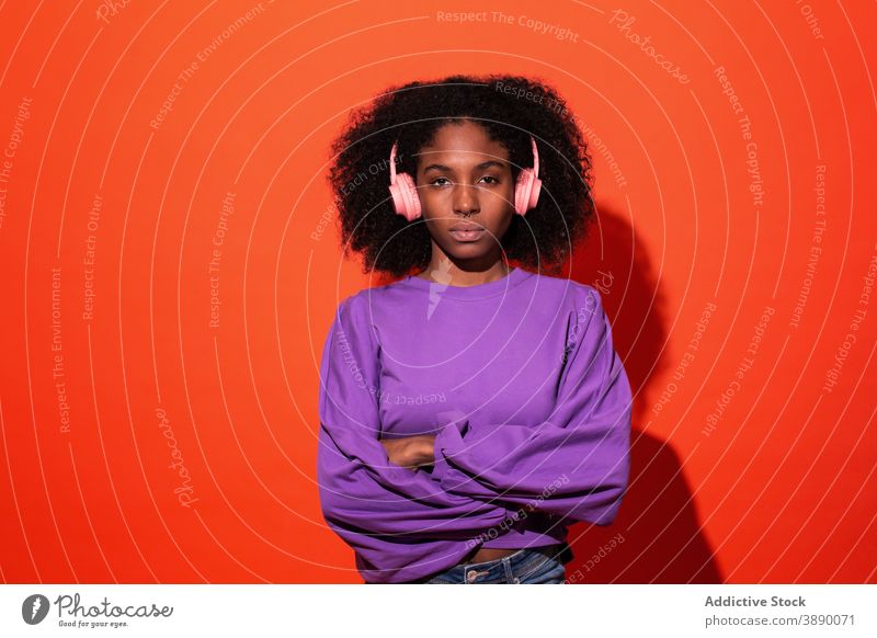 Gefühlslose afroamerikanische Frau mit Kopfhörern Musik lebhaft zuhören Stil emotionslos cool Model tausendjährig Klang trendy Afro-Look ethnisch Afroamerikaner