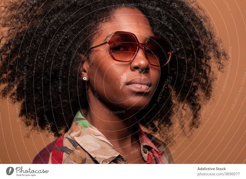 Trendiges schwarzes Modell mit Sonnenbrille Frau exotisch Ornament trendy Kubaner Atelier Körperhaltung geblümt ethnisch Frisur Afroamerikaner Afro-Look cool