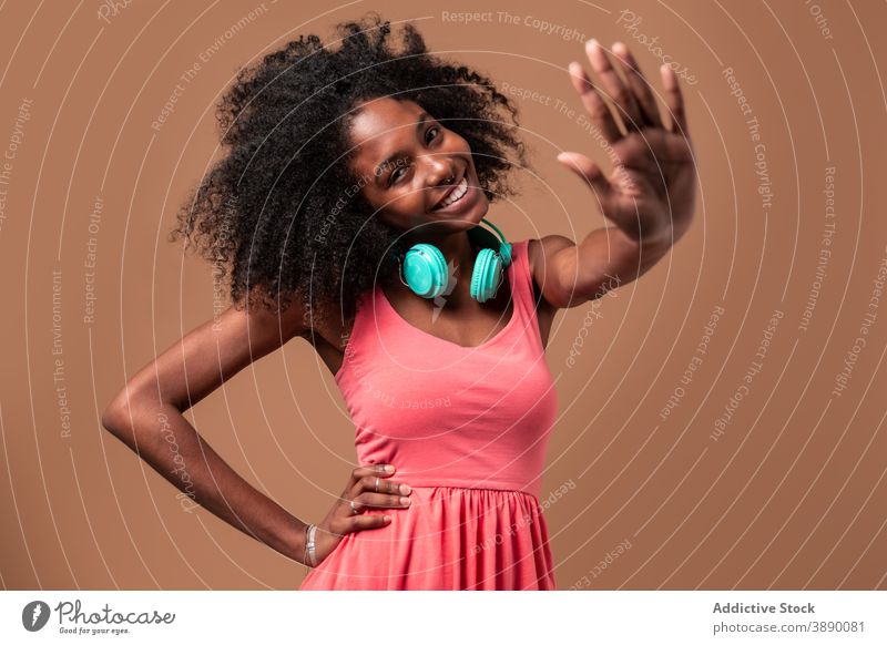 Ethnische Frau mit Kopfhörern im Studio stehend Tanzen Spaß Musik Glück Stil Atelier farbenfroh Frisur Afro-Look ethnisch Kubaner Afroamerikaner schwarz Lächeln