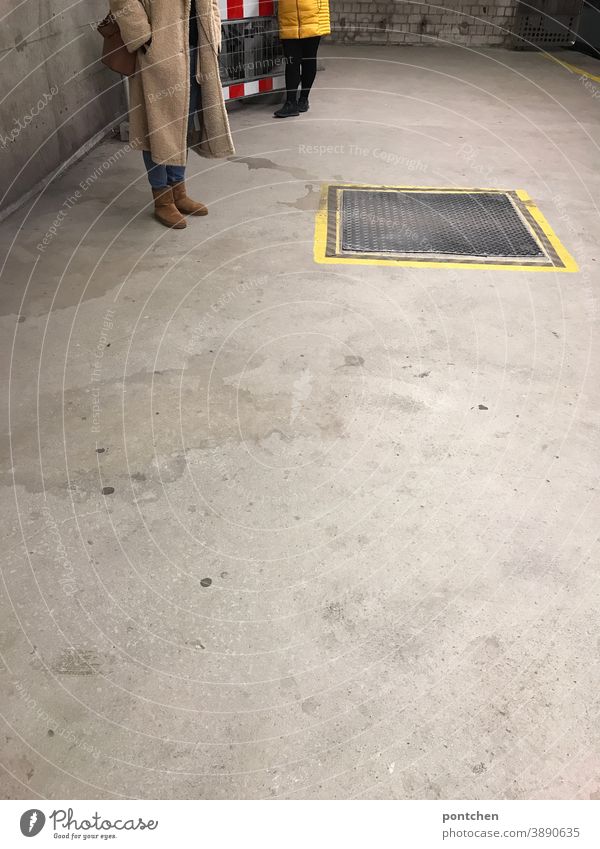 Zwei Frauen in Wintermänteln stehen am Bahnsteig und warten. ubahn wintermantel mode Absperrung markierung gelb kleidung Bahnhof Öffentlicher Personennahverkehr