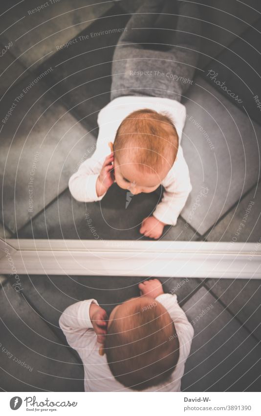 Baby erkundet sein Spiegelbild spannung interessant erkunden niedlich Hand Gesicht