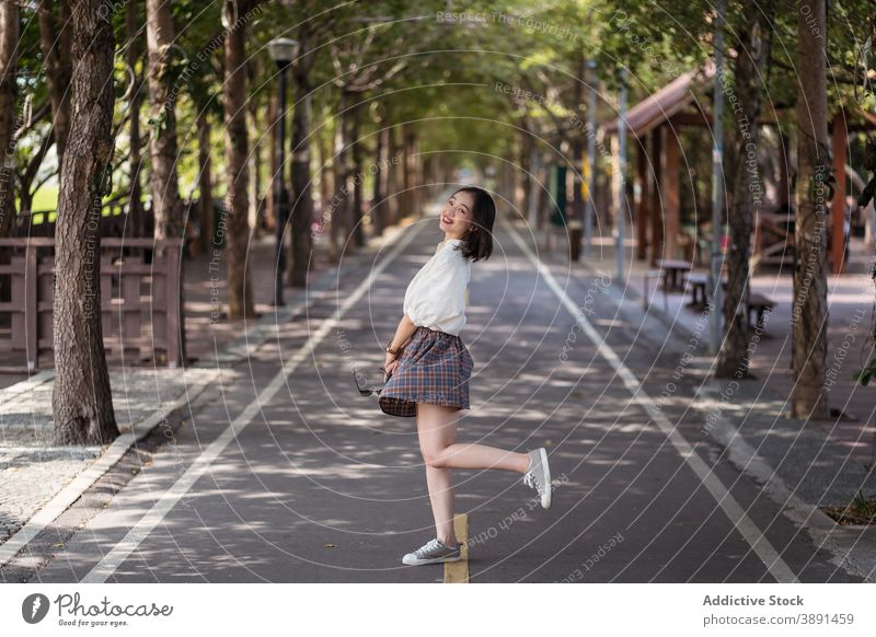 Junge asiatische Frau hat Spaß im Stadtpark Kokette sorgenfrei Park Sommer Spaß haben heiter Lächeln charmant unterhalten ethnisch tanya shen green bikeway