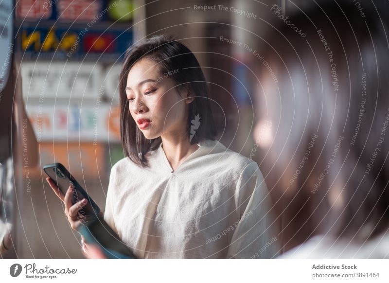 Asiatische Frau benutzt Smartphone in der Stadt Browsen Straße online Surfen Anschluss Kommunizieren Internet Großstadt ethnisch asiatisch Taichung Taiwan