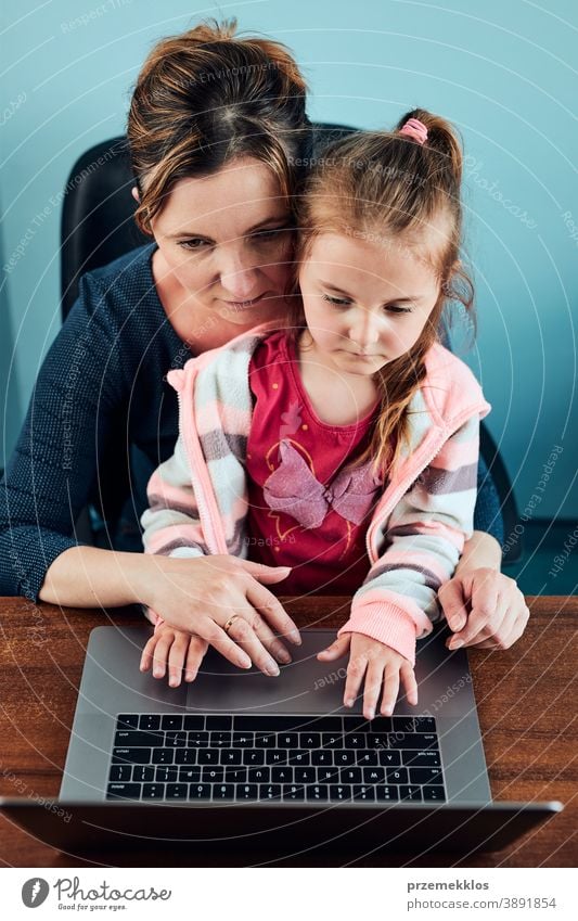 Kleines Mädchen im Vorschulalter lernt online Puzzles zu lösen, indem es zu Hause auf dem Laptop Lernspiele spielt Aufmerksamkeit Kaukasier Kind Kindheit