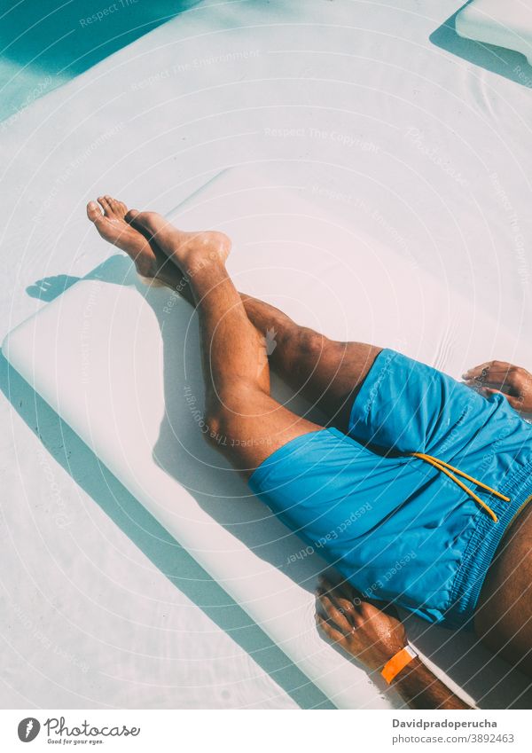Crop Mann ruht auf Liege am Pool Bräune Liegestuhl Sonnenbad Beckenrand Urlaub Sommer Tourist sich[Akk] entspannen Lügen Reisender Resort ruhen sorgenfrei