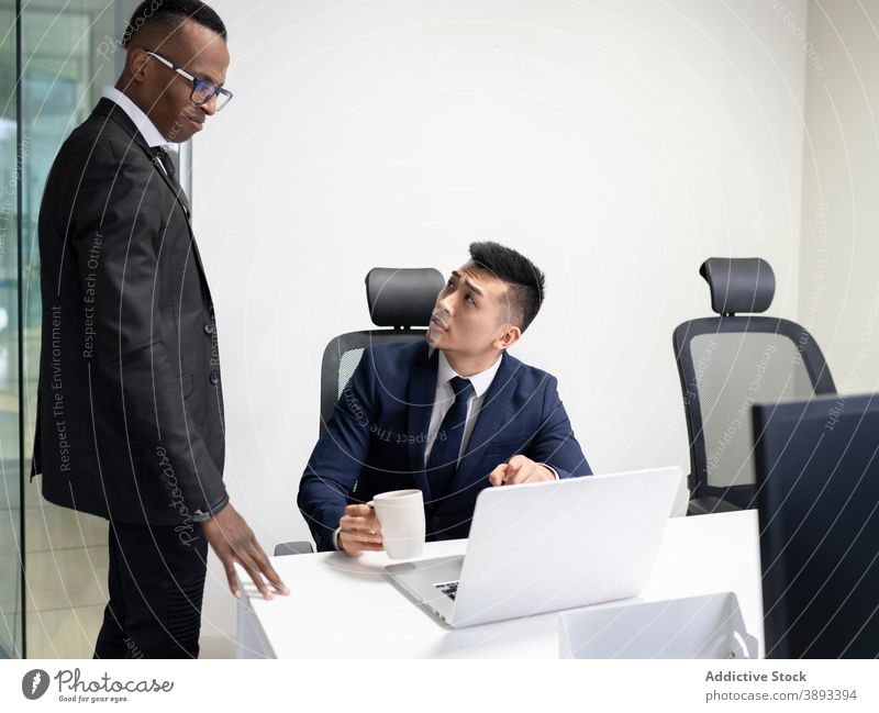 Geschäftsleiter und Manager diskutieren Arbeitsprobleme im Büro Geschäftsleute Chef Laptop Problematik Lösung Punkt zeigen Sitzung ernst jung männlich asiatisch