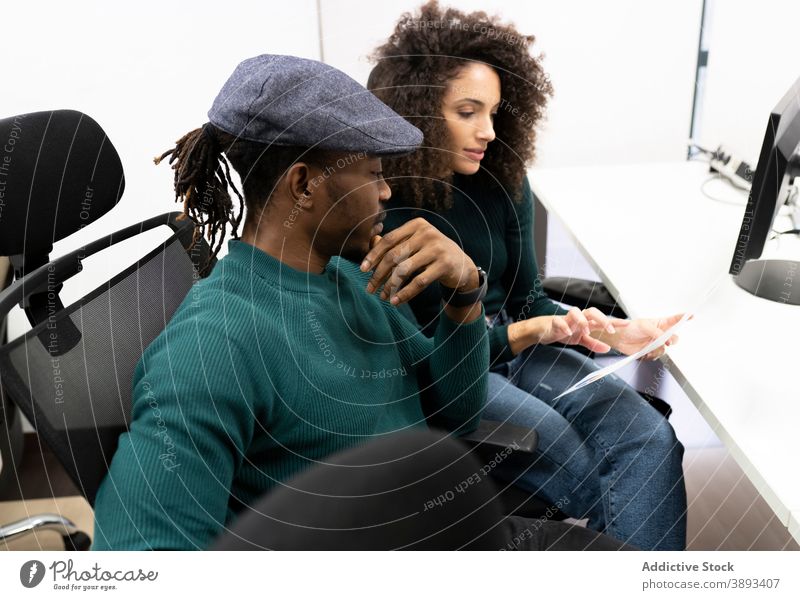 Afroamerikanische Mitarbeiter besprechen Geschäftsergebnisse im Büro Kollege Arbeit Diagramm diskutieren lässig positiv Business Zusammensein Arbeitsplatz