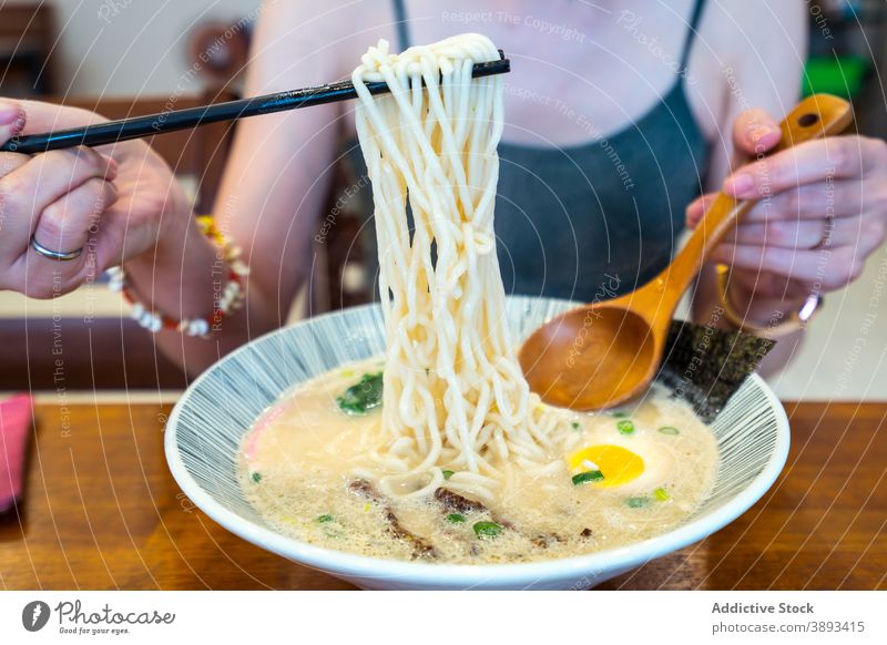 Crop Frau essen asiatische Nudelsuppe im Café Suppe Asiatische Küche Mittagessen Ei Orientalisch Tradition Lebensmittel Restaurant geschmackvoll Tisch Mahlzeit