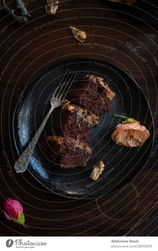 Leckerer Schokoladenkuchen auf schwarzem Teller Kuchen Spielfigur Walnussholz Blume dienen Dessert süß Lebensmittel Gabel Gebäck Nacktkuchen rustikal Ebene