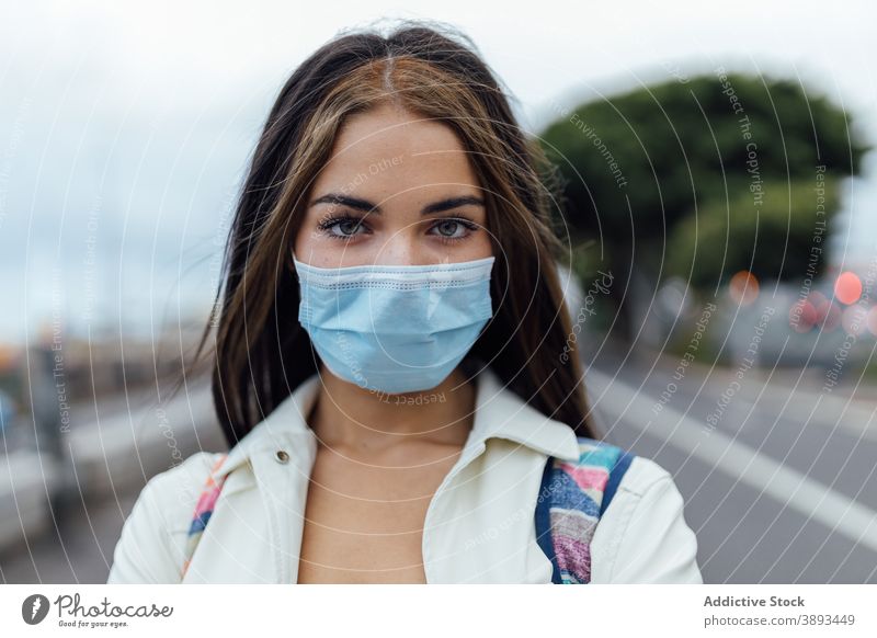 Junge Frau in medizinischer Maske auf der Straße Mundschutz Coronavirus Pandemie Einwegartikel ernst jung Bund 19 COVID Seuche COVID19 tausendjährig verhindern