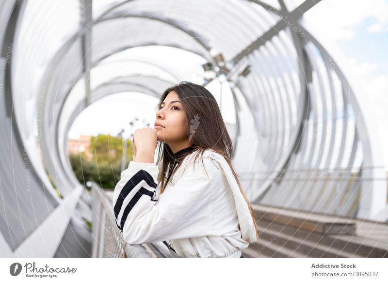 Nachdenkliche Frau steht auf einem Steg Brücke besinnlich nachdenken nachdenklich einsam träumen jung wehmütig Latein ethnisch hispanisch trendy modern Stil