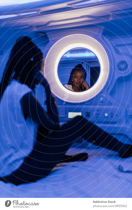Schwarze Frau, die sich in einem Kapselhotel ausruht Hotel Spiegel ruhen Reflexion & Spiegelung Reisender Unterkunft sich[Akk] entspannen Bett jung
