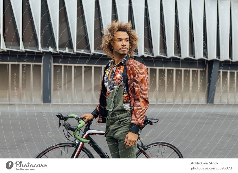 Ethnischer Mann mit Fahrrad stehend auf Stadtstraße Hipster urban jung trendy Arbeitsweg informell Reisender Afroamerikaner schwarz ethnisch Lifestyle männlich