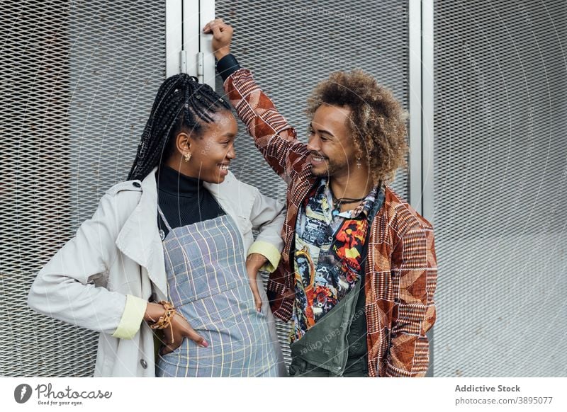 Fröhliche ethnische Freunde reden auf der Straße heiter Talkrunde Glück trendy Sitzung Paar urban positiv jung Hipster Stil modern Afroamerikaner schwarz