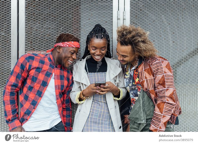 Gruppe von ethnischen jungen Freunden mit Smartphones auf der Straße benutzend Browsen Handy modern trendy Apparatur Surfen Gerät tausendjährig Afroamerikaner