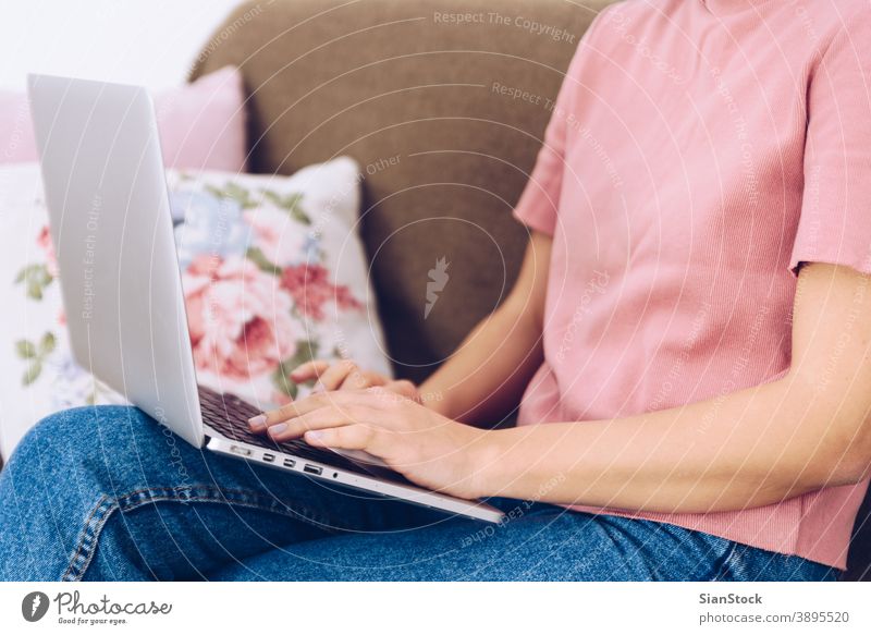 Junge Frau, die auf ihrem Sofa sitzt und bei ihr zu Hause arbeitet. Sitzen arbeiten studierend Kopfkissen Teppich heimwärts Innenbereich schön Porträt Raum
