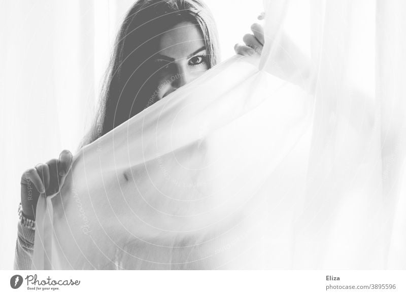 Portrait einer Frau, die hinter einem weißen Vorhang hervorschaut in Schwarzweiß weißer Stoff lasziv Augen Blick Schwarzweißfoto schön Vorgang