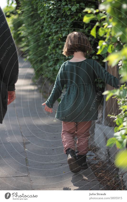 Ein Mädchen läuft Spazieren spazieren draußensein drausen Herbst Sommer Kleid kurze haare Gartenzaun Wege & Pfade Gartenhecke grün Stadt gehwegplatte laufen