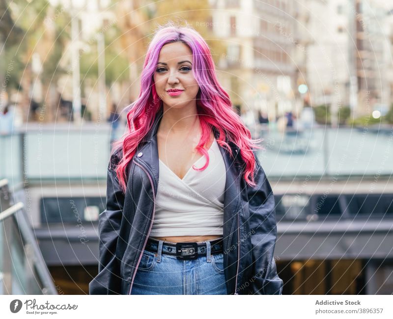 Junge Frau mit gefärbten Haaren steht auf der Straße gefärbtes Haar rosa Haare positiv alternativ tausendjährig urban Lederjacke Stil trendy selbstbewusst