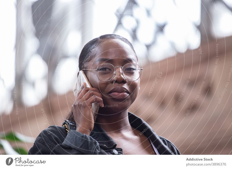 Schwarze Frau spricht auf Smartphone auf der Straße reden ernst Telefon Kommunizieren urban Gespräch zuhören sprechen jung Afroamerikaner schwarz ethnisch