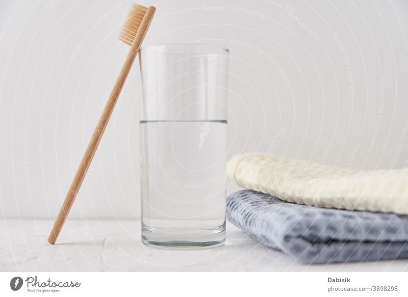 Bambus-Zahnbürste aus Glas und Badetücher auf weißem Hintergrund Bürste Schönheit Pflege Gesundheit hölzern Öko ökologisch Hygiene organisch Holz Sauberkeit