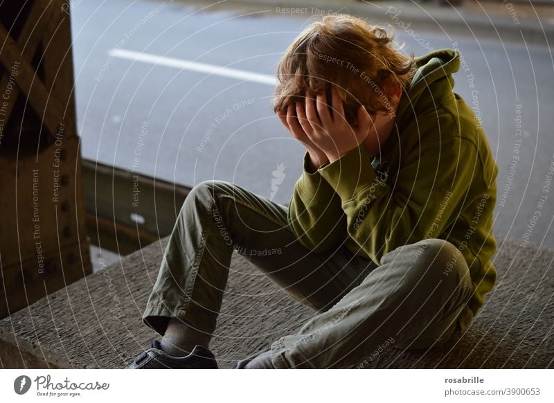 Lebensbrüche  | kleiner Junge sitzt verzweifelt mit den Händen vor dem Gesicht weinend in einer Unterführung traurig Kind alleine Trauer Sorge Angst Verlust