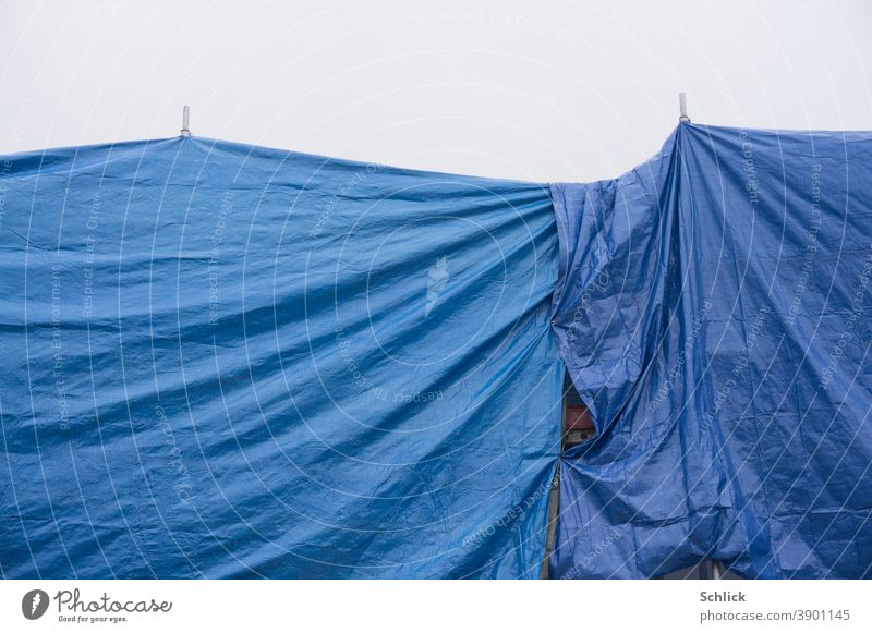 Verhüllt Baugerüst und Dach mit blauen Plastikplanen abgedeckt Schutz vor Regen Plane verhüllt Farbfoto Außenaufnahme Menschenleer Abdeckung Kunststoff