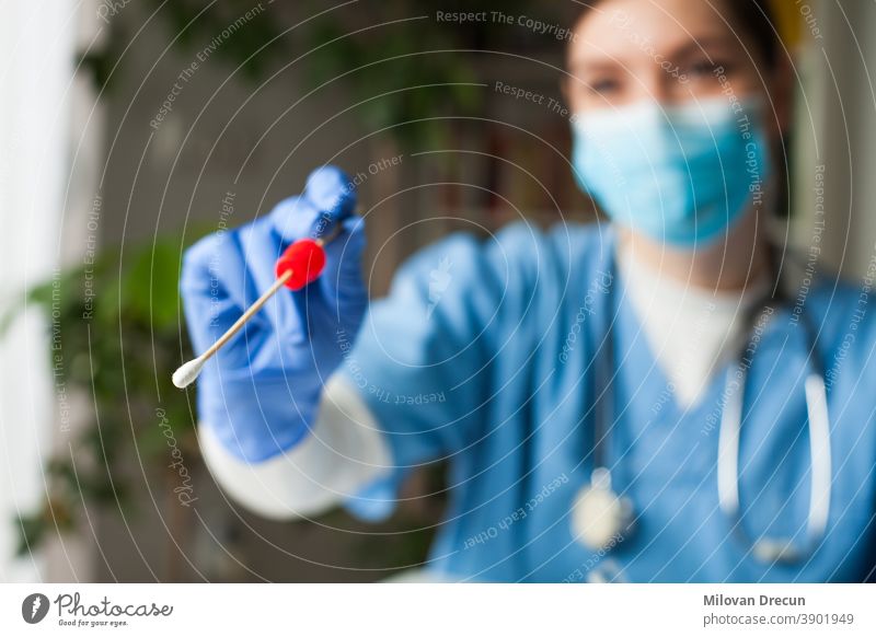Weibliche kaukasische NHS-Ärztin mit einem Abstrichstäbchen in der Hand, Abstriche von nasalen und oralen Proben in der Arztpraxis, Ernennung der Patientin zum PCR-Testverfahren, Coronavirus COVID-19 globale Pandemie-Krise