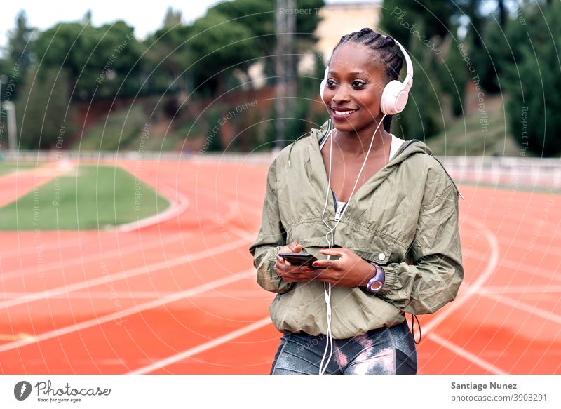 Sportler Sprinter sitzend, Musik hörend Smartphone Afro-Look Konzentration Technik & Technologie Zelle Funktelefon Schutzhelm Mobile Athlet ethnisch