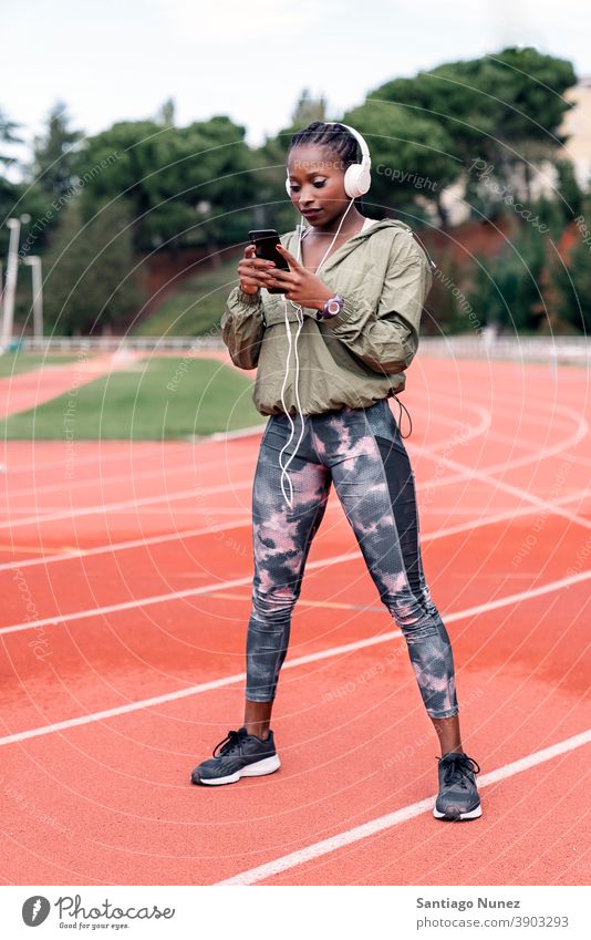 Sportler Sprinter sitzend, Musik hörend Smartphone Afro-Look Konzentration Technik & Technologie Zelle Funktelefon Schutzhelm Mobile Athlet ethnisch